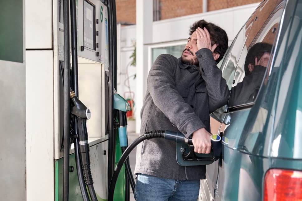 Mann erschreckt sich beim Tanken vor dem Kraftstoffpreis